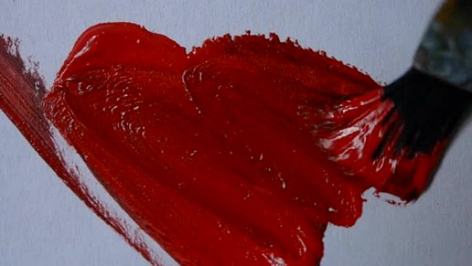 用画笔在白纸上用红色油漆画画