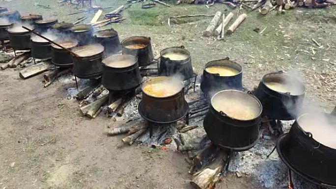 在树林里的明火上的大锅中烹饪