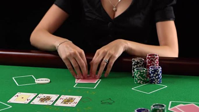 扑克玩家看着她的牌和赌注。赌博、风险、运气、赢、乐趣和娱乐的概念。普洛雷斯·富勒德