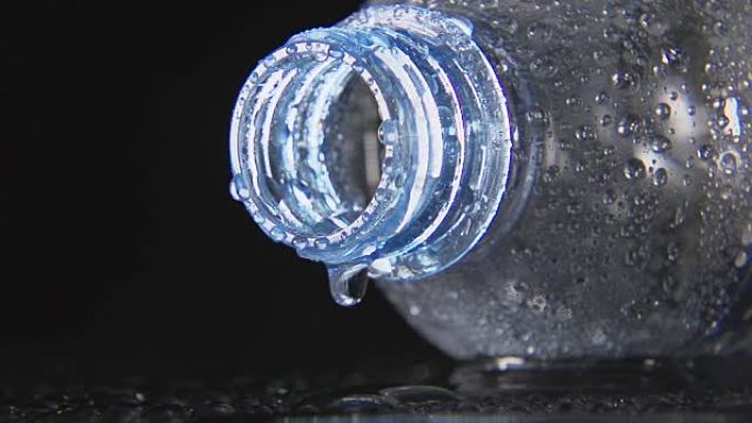缓慢: 水滴从塑料瓶的脖子上掉下来 (特写)
