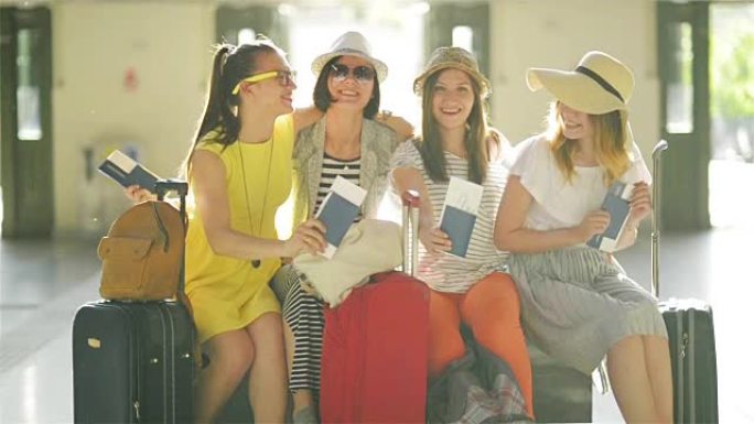 四名手持大行李箱的女性旅客坐在机场候车室，手里拿着护照和机票