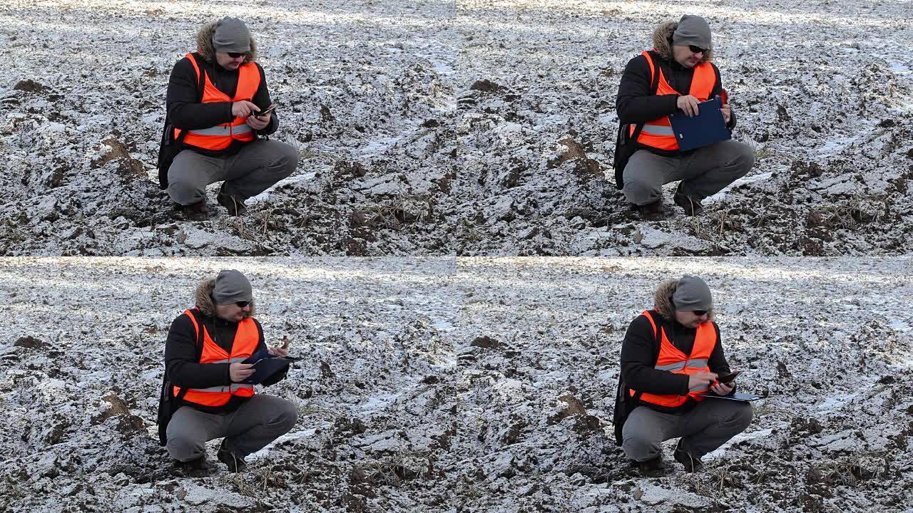 冬季在冰冻的土地上使用平板电脑的农民