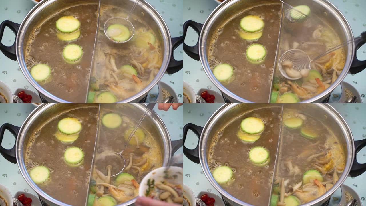 概念火锅亚洲烹饪。从skimmer到酱汁的煮汤中取出蘑菇和西葫芦
