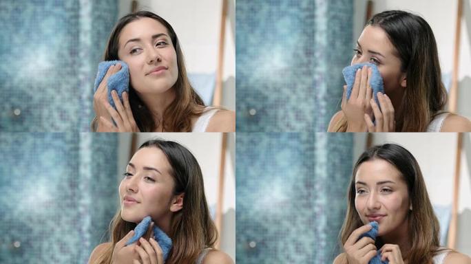 年轻迷人的女人用毛巾洗脸