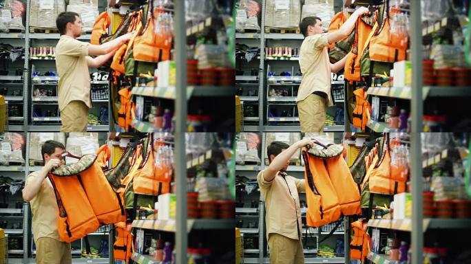 一名成年男子在购物中心选择橙色救生衣进行安全游泳