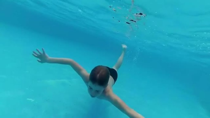 快乐的孩子在游泳池的水下尽情游泳