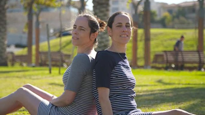 同卵双胞胎坐在公园里