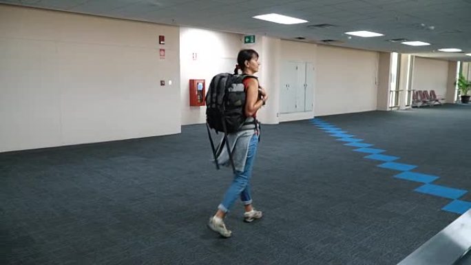 女人在空荡荡的机场走廊上行走