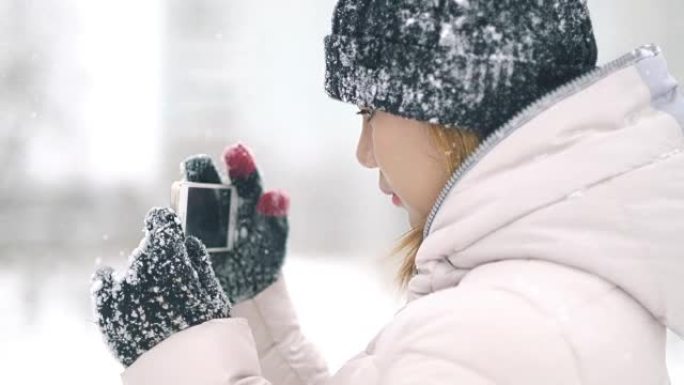 年轻女子在降雪期间拍照