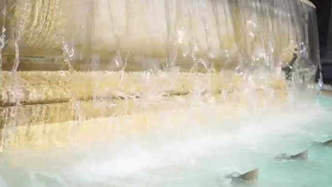 旧黄色大理石喷泉水幕的特写。透明的水流。夏季晴天