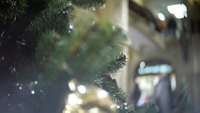 滑入金色哑光和镜面球。新年和抽象模糊购物中心背景与圣诞树装饰