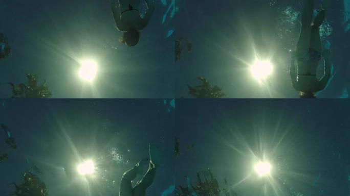 女人在相机上方游泳仰泳，底视图