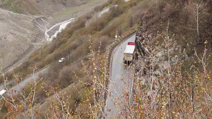 山地景观。山里经过的路。汽车在山上沿着道路行驶。高加索山脉的道路蛇形。汽车交通运输顶视图