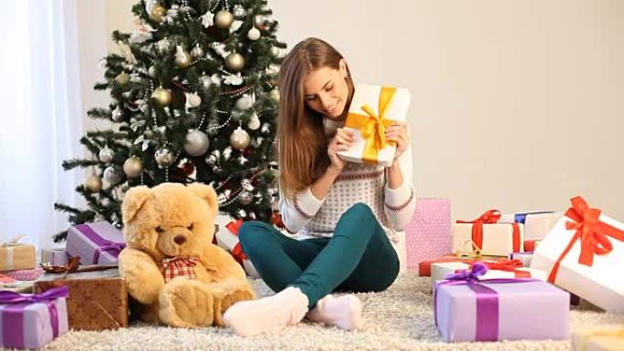 坐在圣诞树旁边的女孩和圣诞礼物