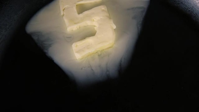 五号黄油在热锅上融化-特写顶视图