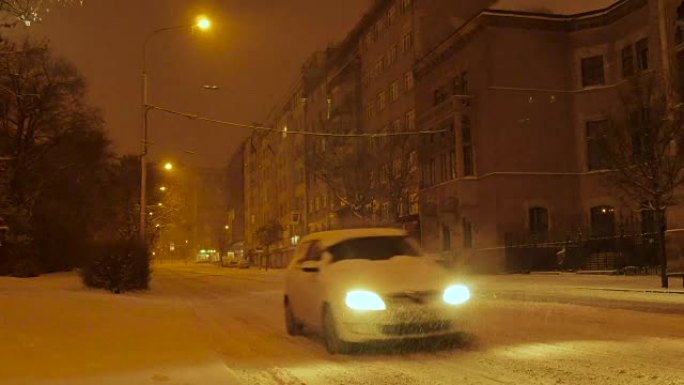 汽车骑在中欧白雪覆盖的街道上，夜晚