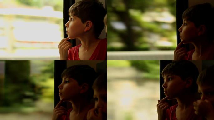 坐火车旅行的小男孩。孩子看着火车窗外。孩子在火车窗外观察