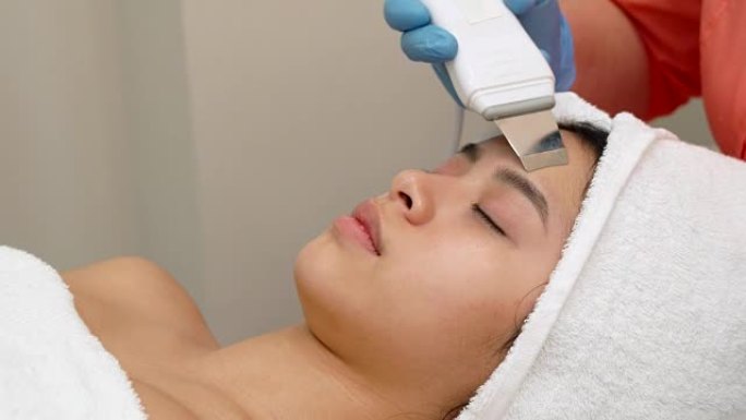 美容专家为女性客户的脸部进行超声波脱皮