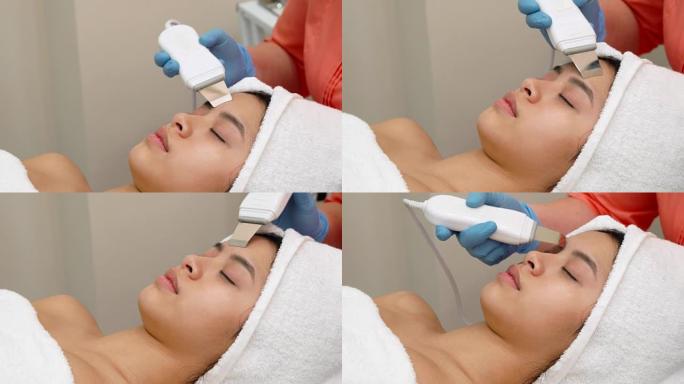 美容专家为女性客户的脸部进行超声波脱皮