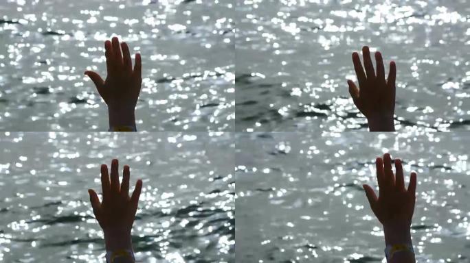 海上背景上的小女孩的手