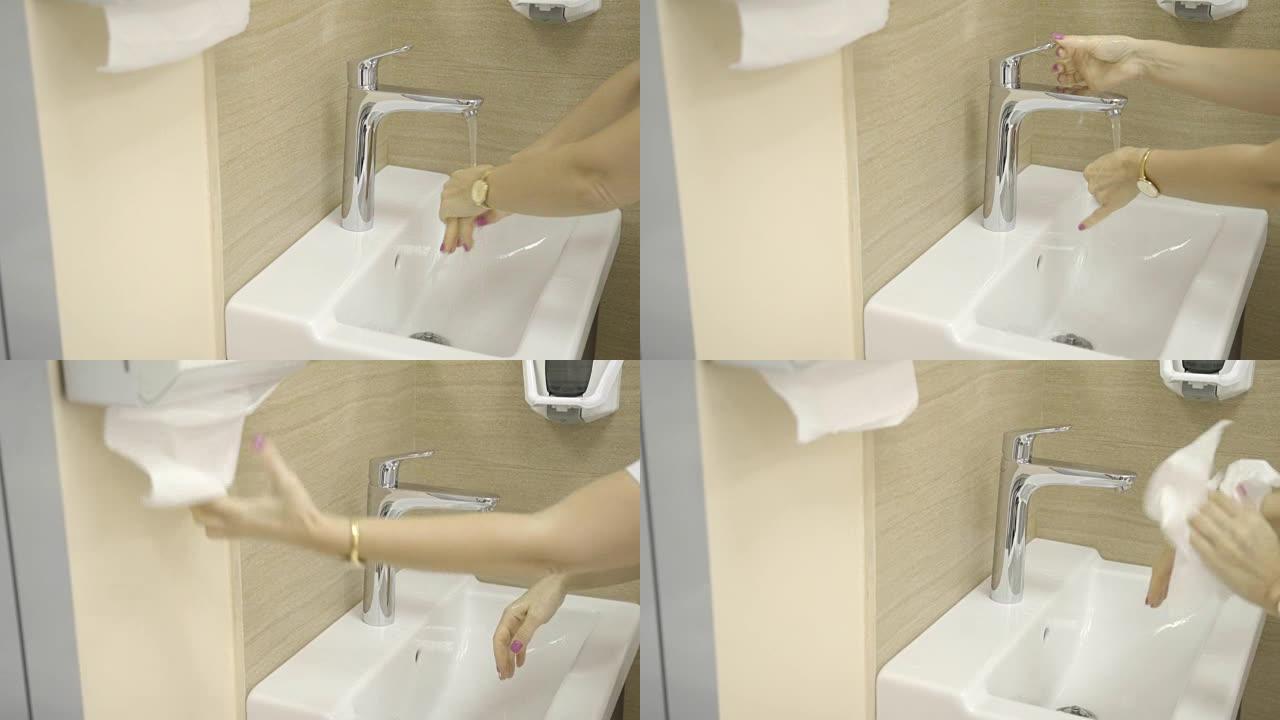 医生在室内的水龙头和诊所的湿巾下，用抗菌肥皂在强烈的水流下小心地洗手