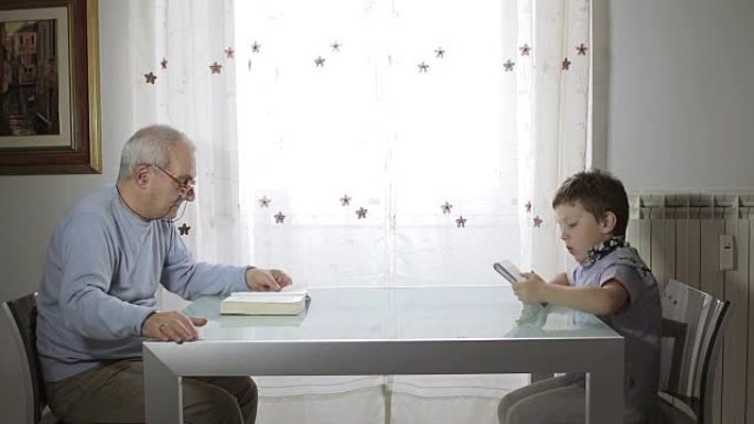 过去和未来，祖父读书和孩子使用平板电脑
