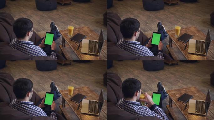 平板电脑欢迎伴侣的男人，一个绿色的屏幕