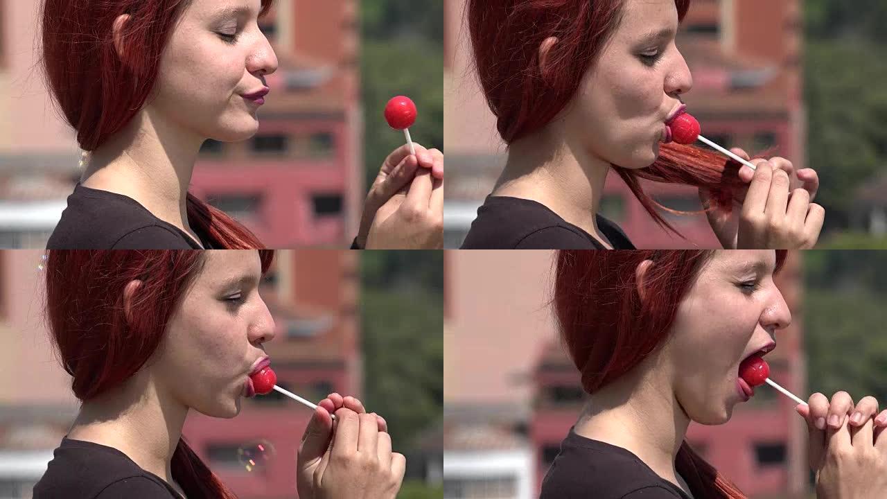 红发青少年女性吃红色棒棒糖