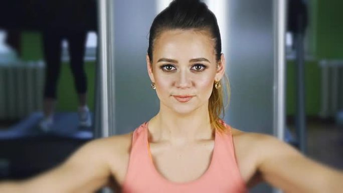 女人在健身房用重物在蝴蝶机上进行健身训练