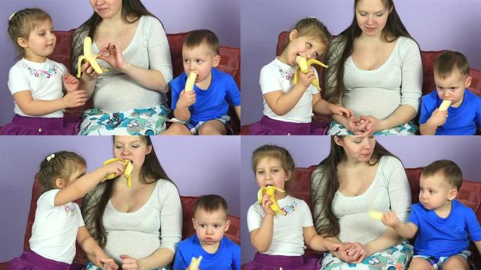 孕妇有年幼的孩子吃香蕉。幸福的家庭等待第三个孩子