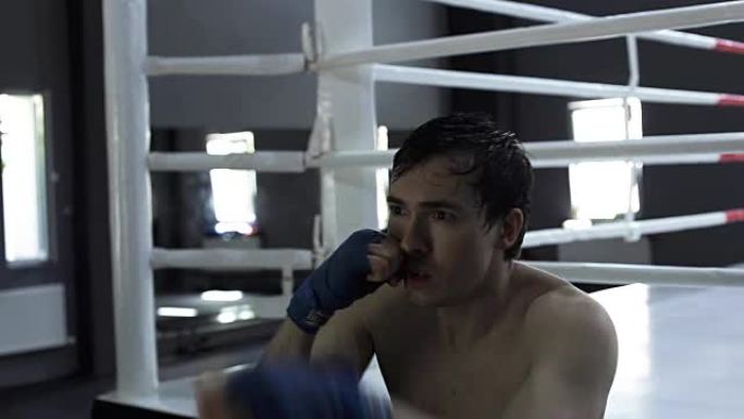 男子拳击手在拳击馆练习沙袋