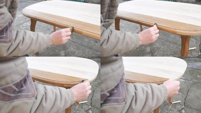木匠正在用漆覆盖桌子