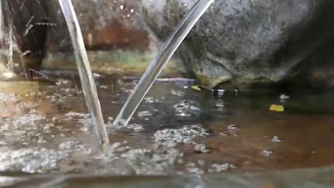 关闭花园喷泉处的水滴，水滴溅到水面上。