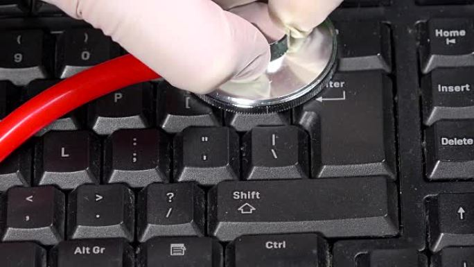 黑色键盘上有听诊器的电脑医生。电脑维修服务。