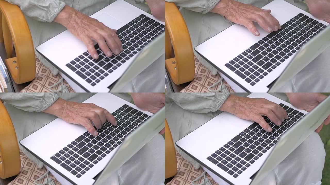 奶奶正在笔记本电脑键盘上打字。