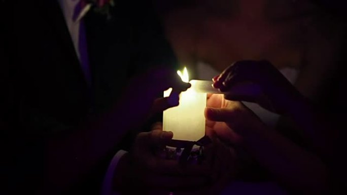 新娘和新郎拿着一支燃烧的蜡烛