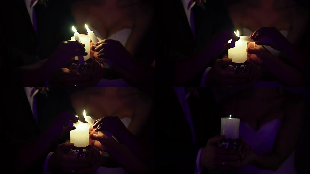 新娘和新郎拿着一支燃烧的蜡烛