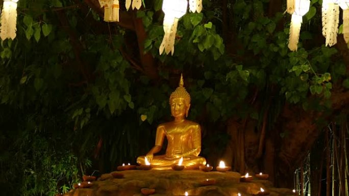 带烛光和纸灯笼的金色佛像雕像