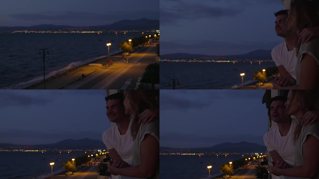 夫妇晚上从酒店阳台看海