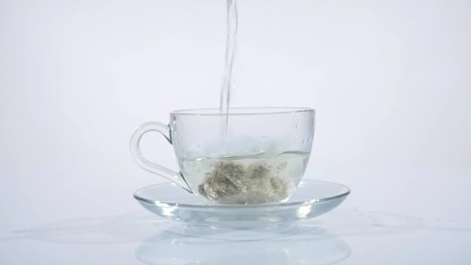 茶袋放在玻璃杯里，里面装满热水泡茶。慢动作