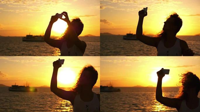 漂亮女人在海上航行中对着日落自拍。慢动作。
