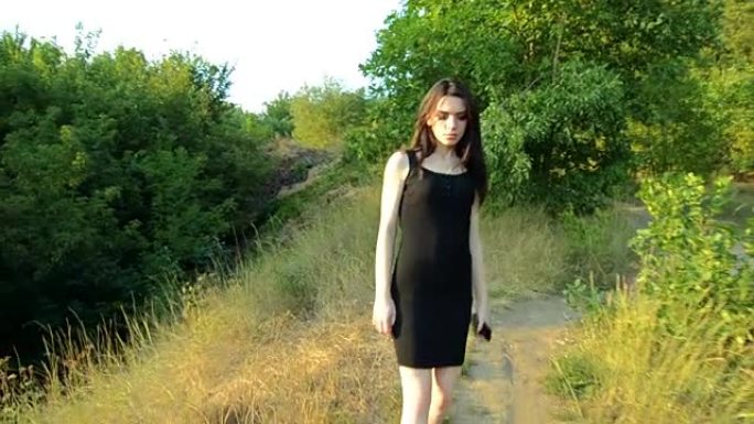 一个穿着黑色连衣裙的美丽年轻女子走在街上