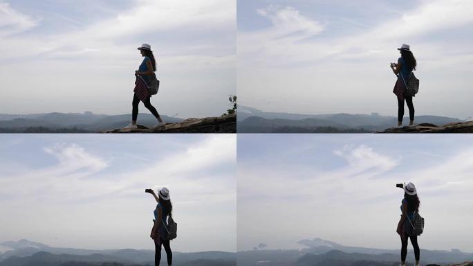 山顶上的女孩，女游客用手机拍摄日出的早晨风景