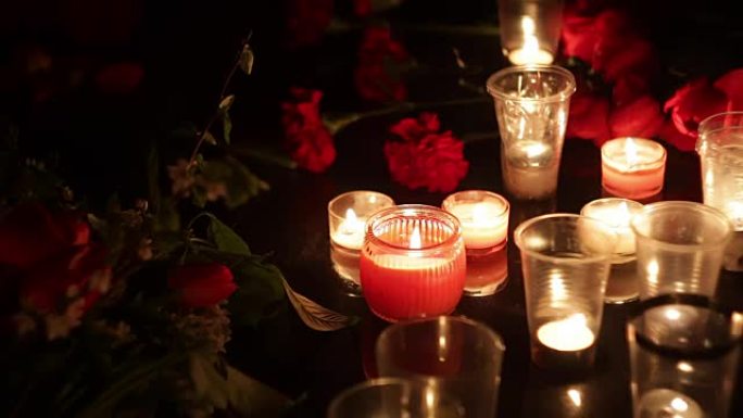 纪念，鲜花和蜡烛，以纪念那些被恐怖袭击和军事行动杀害的人。悲伤，同情和人们的眼泪