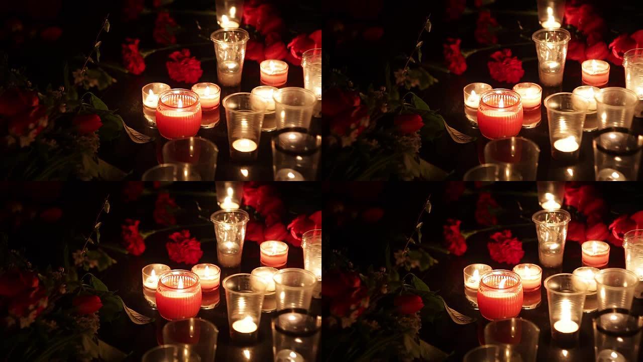 纪念，鲜花和蜡烛，以纪念那些被恐怖袭击和军事行动杀害的人。悲伤，同情和人们的眼泪
