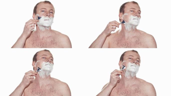 成年男子用泡沫剃须和手动刮胡刀剃须。慢动作