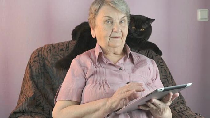 老年妇女在室内看着黑猫