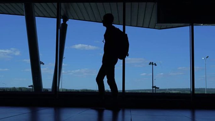 一个背着背包的男人走在机场候机楼