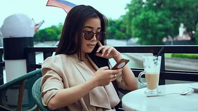 可爱华丽的亚洲女人，带着咖啡和电话