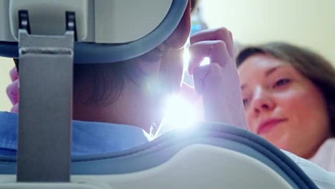 女牙医开灯检查病人的低角度特写